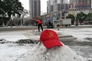 区残联党员志愿者街头铲雪保畅通